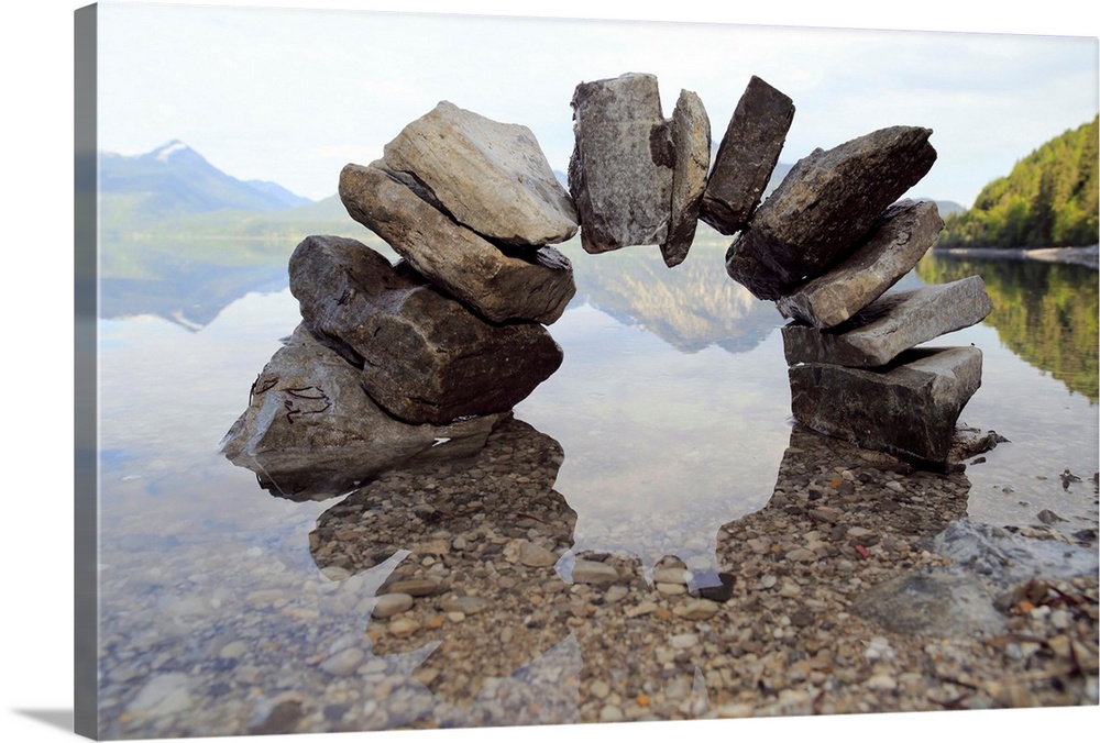 Small stone arch casting reflecting in shallow water.