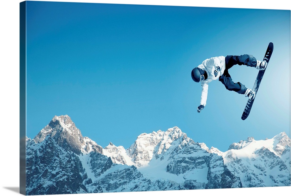 Snowboarder making jump high in clear sky, with mountains in the background.