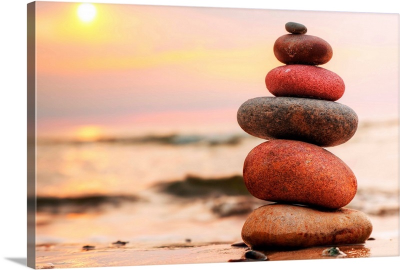 Stacked stones on a beach at sunset Great Big Canvas