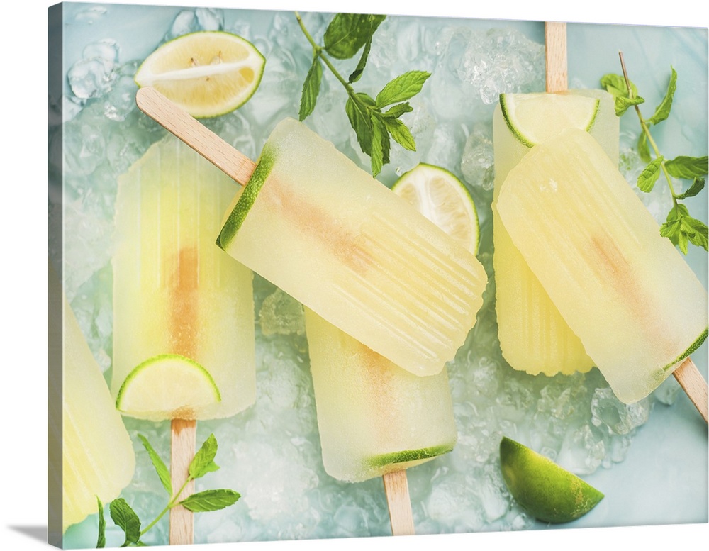 Summer refreshing lemonade popsicles with lime and mint with chipped ice over blue background, top view.