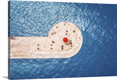 Top Aerical View Of Red Lighthouse Against Blue Water Of Sea