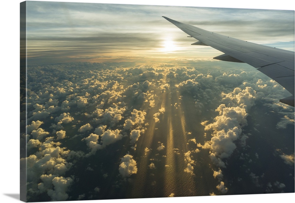 View From Airplane Side Window Of Sunset Sky And Sunlit Clouds