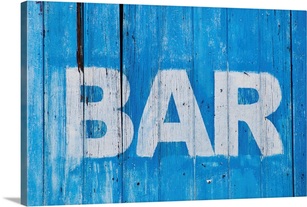 White bar sign painted on a dilapidated blue wooden wall