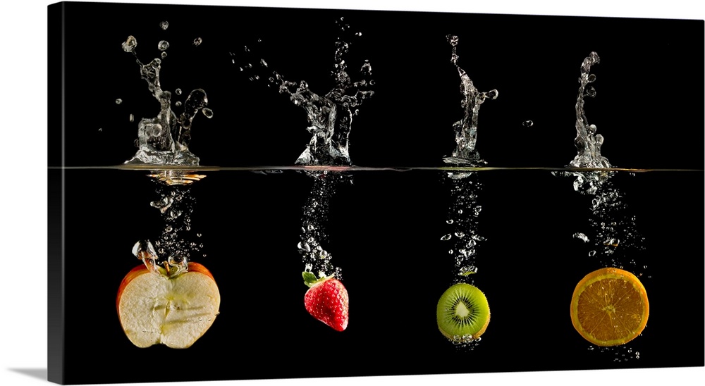 Fruit dropped into water creating a glass like water splash and bubbles.