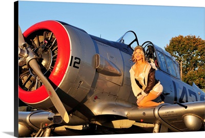 1940's style aviator pin-up girl posing with a vintage T-6 Texan aircraft