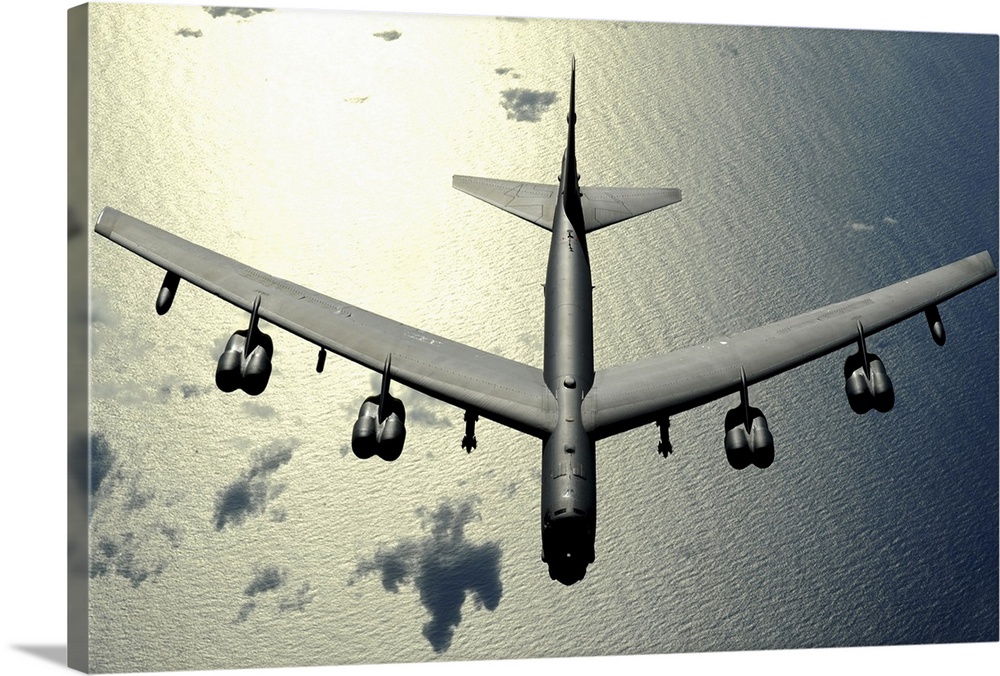 Horizontal aerial photograph on a  big wall hanging, looking down at the top of a B52 Stratofortress  as it flies over the...