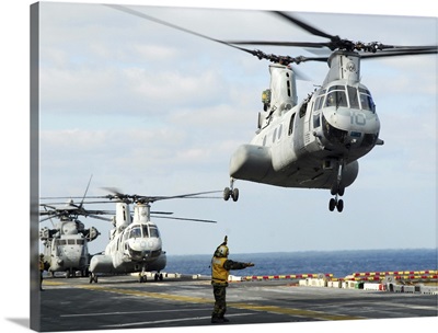 A CH-46E Sea Knight helicopter takes off from the flight deck of USS Essex