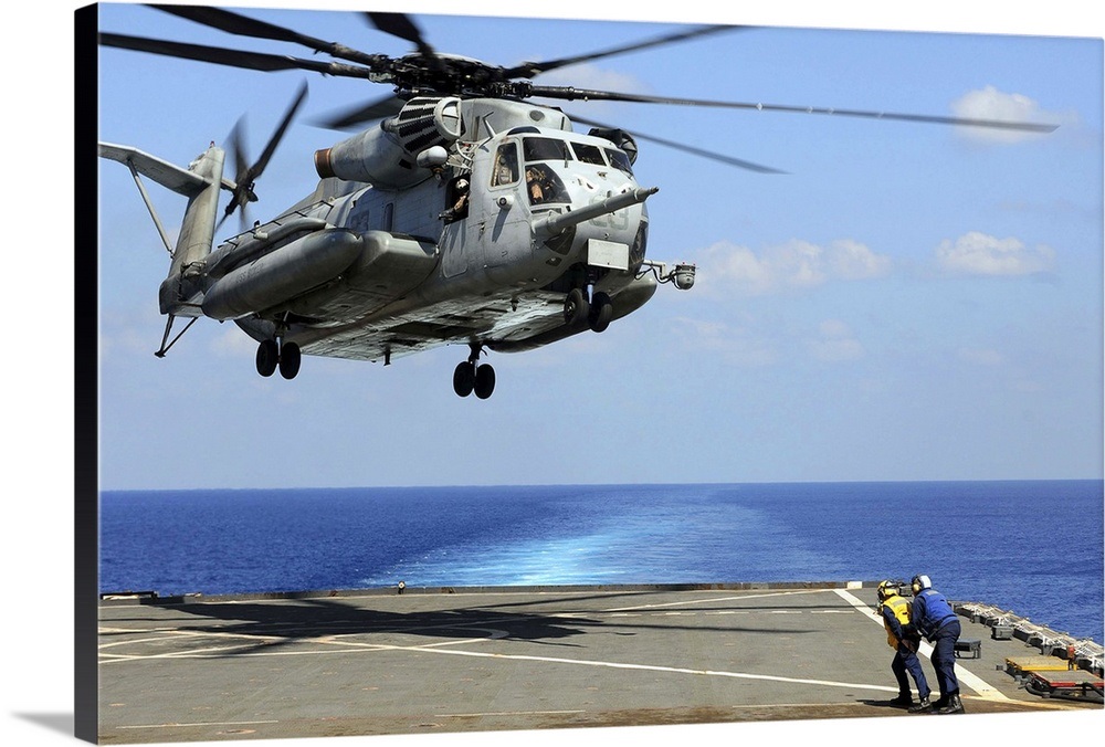 A CH-53E Super Stallion lifts off from an amphibious dock landing ship ...