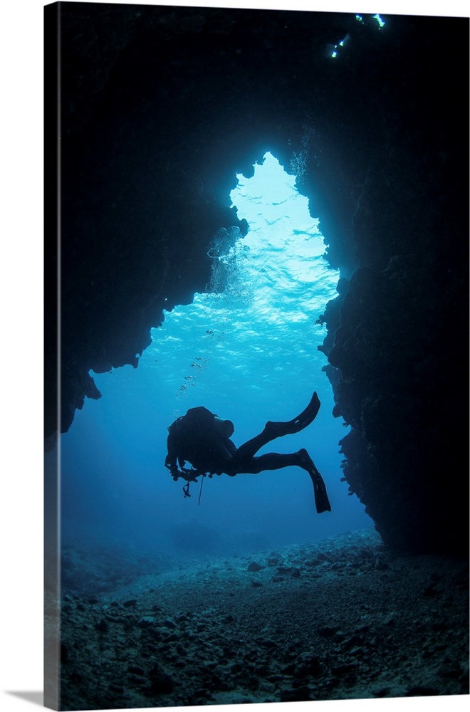 A diver exiting a swim through cavern, Kadavu Island, Fiji.