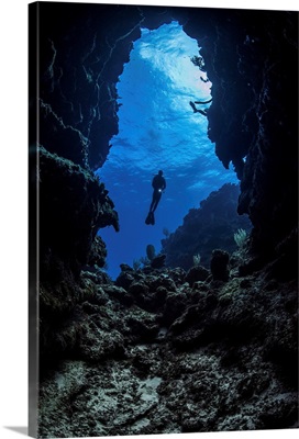 A diver stops at the entrance to an underwater cave in Grand Cayman, Cayman Islands