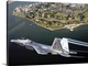 image thumbnail of A militarty fighter jet flies past Fort Monroe with water vapor trails shooting from the wings of the plane.