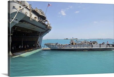 A landing craft utility approaches the well deck of USS Essex