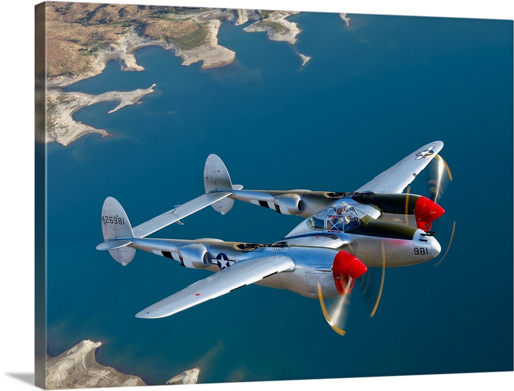 Canvas photo art of a vintage airplane flying above water.