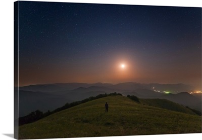 A lone man stands on the mountains at night under the moon, Sudak, Crimea
