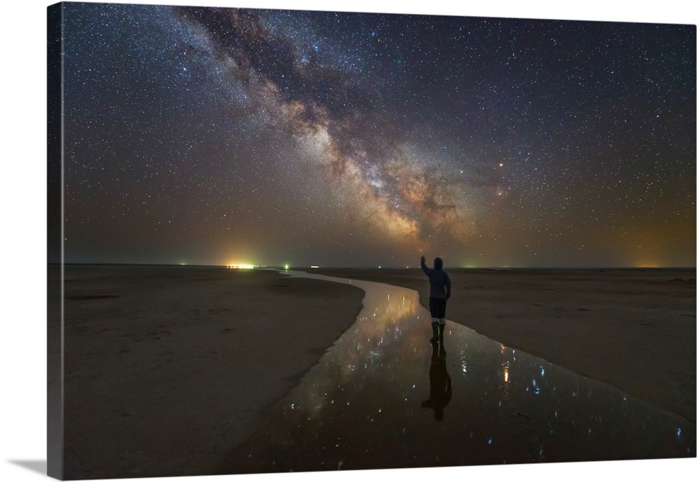 A man walking on the salt river at night under the Milky Way, Russia.
