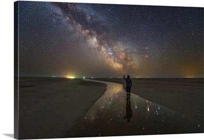 A man walking on the salt river at night under the Milky Way, Russia