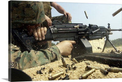 A Marine engages targets with an M249 Squad Automatic Weapon