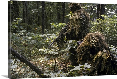 A Marine sniper team wearing camouflage ghillie suits