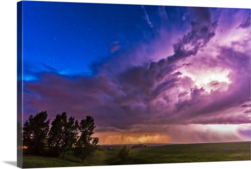 June 20, 2014 - A massive thunderstorm moves across the northern horizon lit internally by lightning. The clear sky behind...