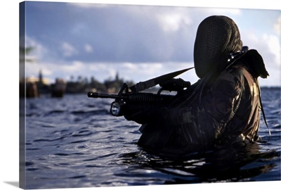 A Navy SEAL emerges from underwater during a training exercise