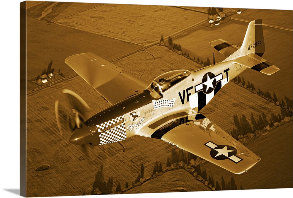 Big, horizontal photograph of a North American P-51D Mustang in flight near Columbus, Ohio, over farm fields.