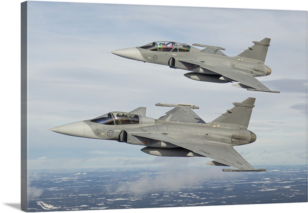 A pair of Swedish Air Force JAS-39 Gripen fighter jets in flight over northern Sweden.