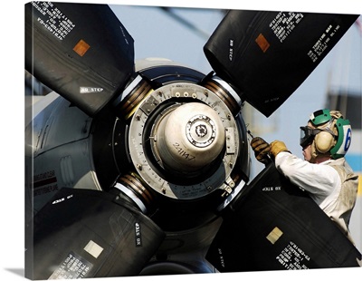 A Sailor Performs Maintenance On The Propeller Of An E-2C Hawkeye