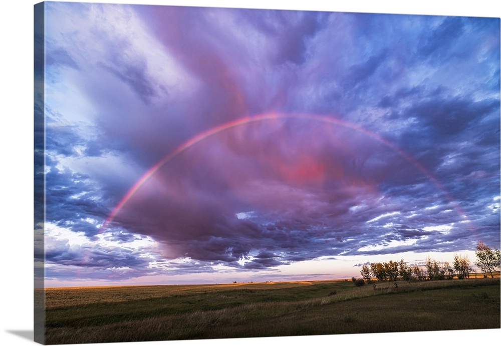 A Semi-Circular Rainbow At Sunset, Set Amid Red Clouds, Alberta, Canada