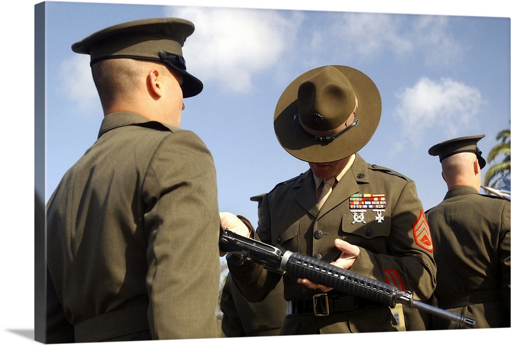 A senior drill instructor inspects a recruits rifle for cleanliness