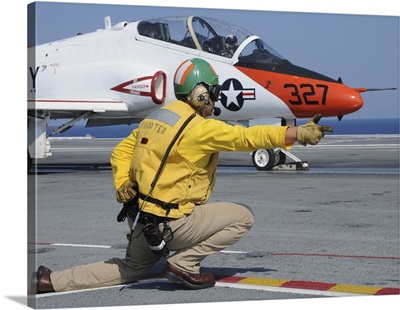A shooter signlas the launch of a T-45A Goshawk trainer aircraft