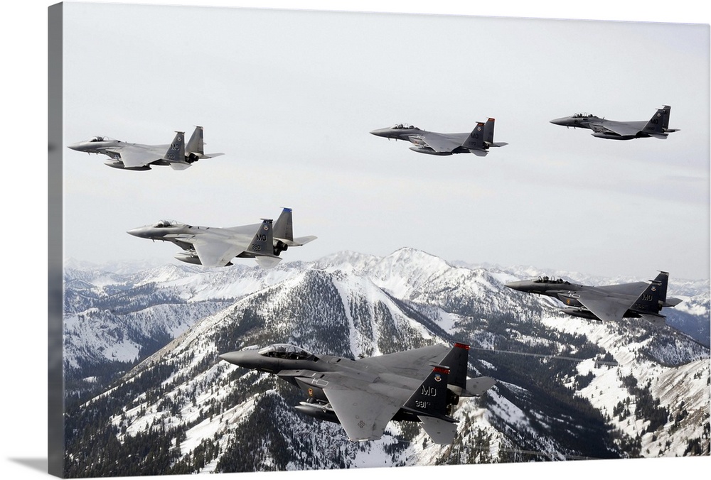 Photograph of airplanes or jets flying over snow covered mountains.