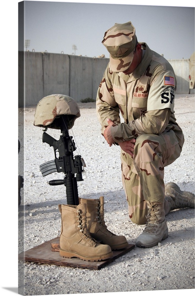 A soldier bows to pay tribute to a fallen soldier.