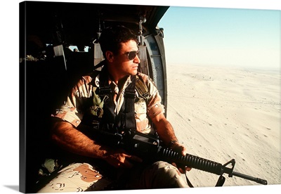 A soldier scans the horizon from inside a helicopter during Operation Desert Storm