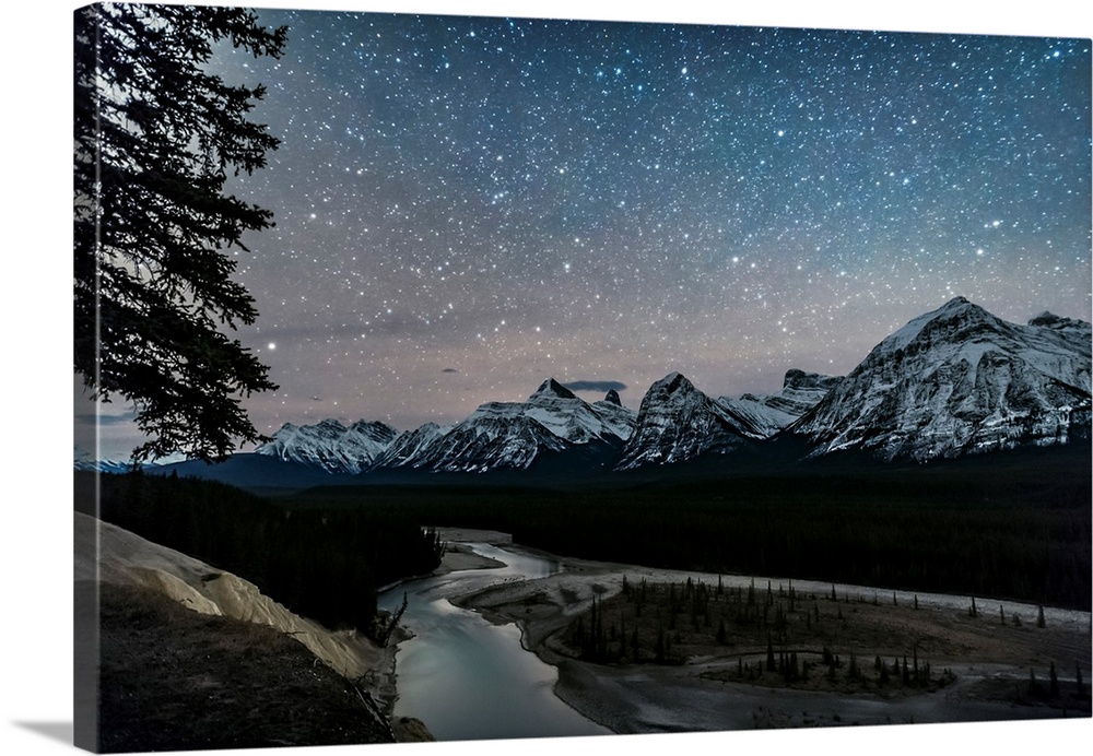 A starry sky over the Athabasca River and continental divide, Alberta, Canada.