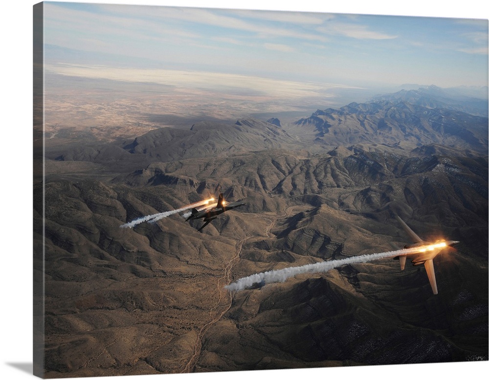 A two-ship of B-1B Lancers release chaff and flares while maneuvering over New Mexico.