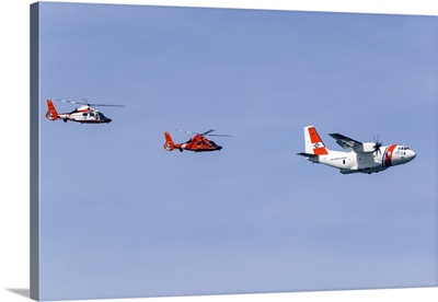 A U.S. Coast Guard C-27J Flying In Formation With Two MH-65 Dolphin Helicopters