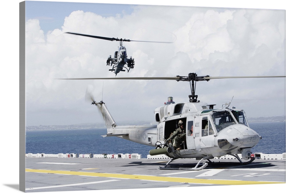 A UH-1N Huey and an AH-1W Super Cobra land on flight deck of USS Essex.
