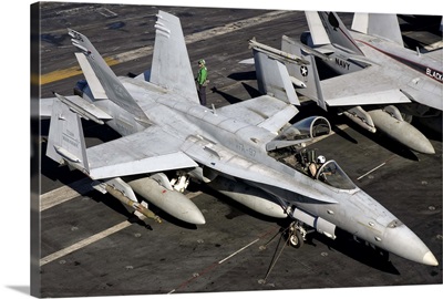 A US Navy F/A-18C Hornet parked on the flight deck of USS Nimitz