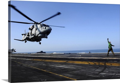 Airman Directs An EH-101 Merlin Helicopter Onto The Flight Deck Of USS John C Stennis