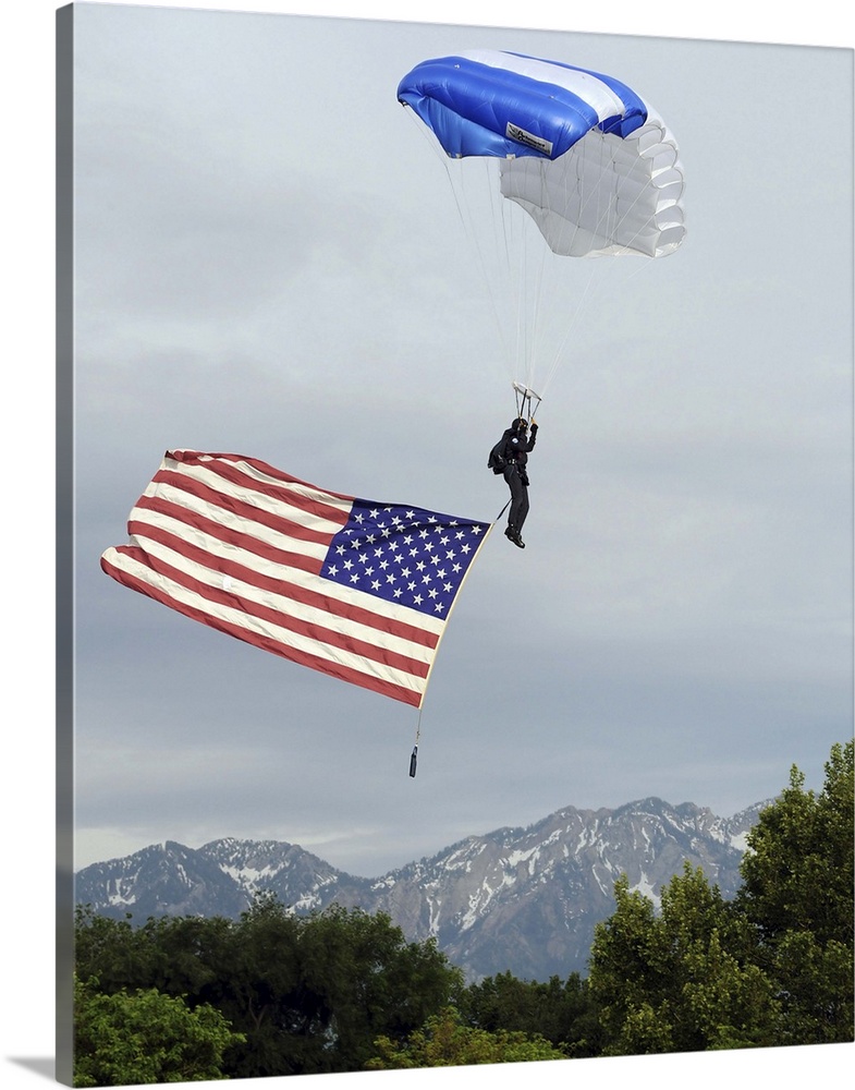 Airman floats through the sky carrying the American flag.