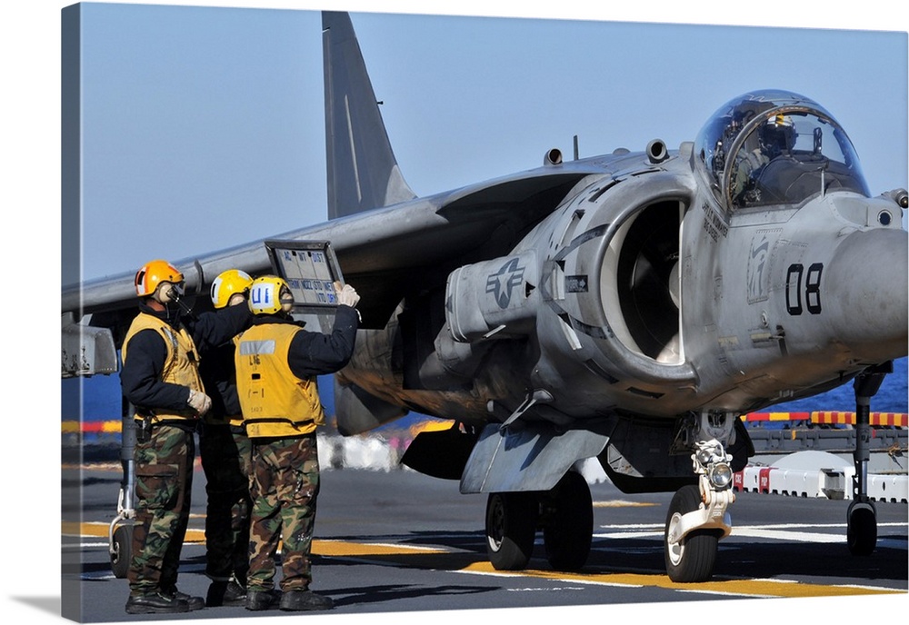Airmen show flight information to an AV-8B Harrier pilot.