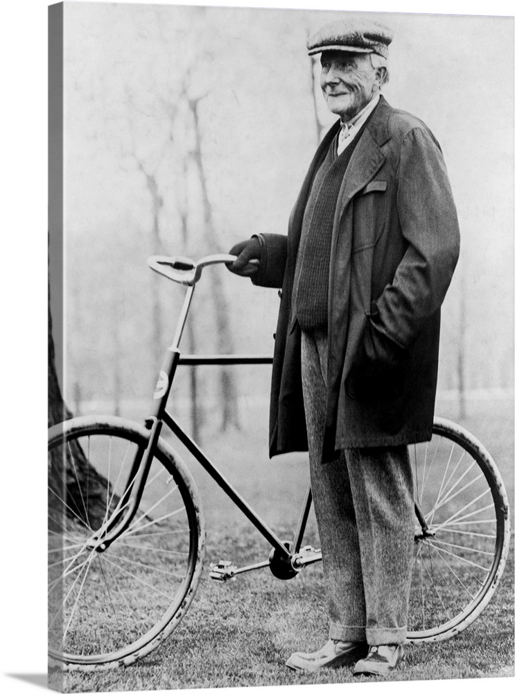 American business magnate John D. Rockefeller standing beside a bicycle in 1913.
