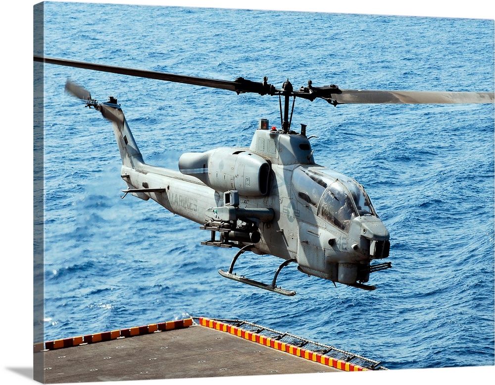An AH-1W Super Cobra helicopter launches off the flight deck of USS Peleliu.