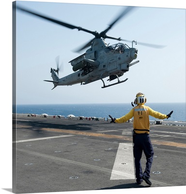 An AH-1Z Cobra helicopter takes off from the flight deck of USS Makin Island