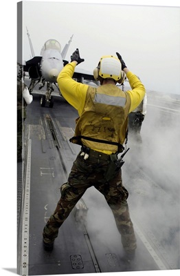 An Aircraft Director Signals A F/A-18C Hornet On The Flight Deck Of USS Kitty Hawk