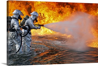 An aircraft rescue firefighting team attempts to spray out a fuel fire
