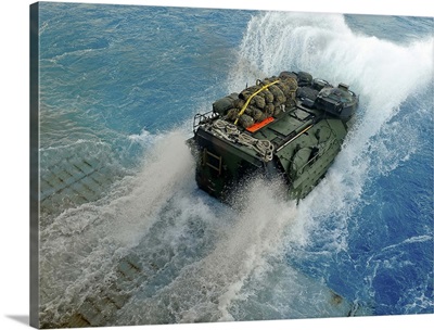 An amphibious assault vehicle exits the well deck of USS Fort McHenry