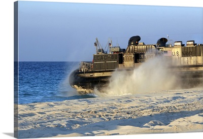 An assault craft heads back to sea after dropping off cargo during an offload