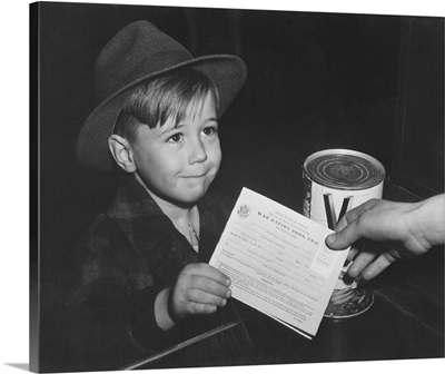 An eager school boy gets his first experience in using War Ration Book Two, circa 1943