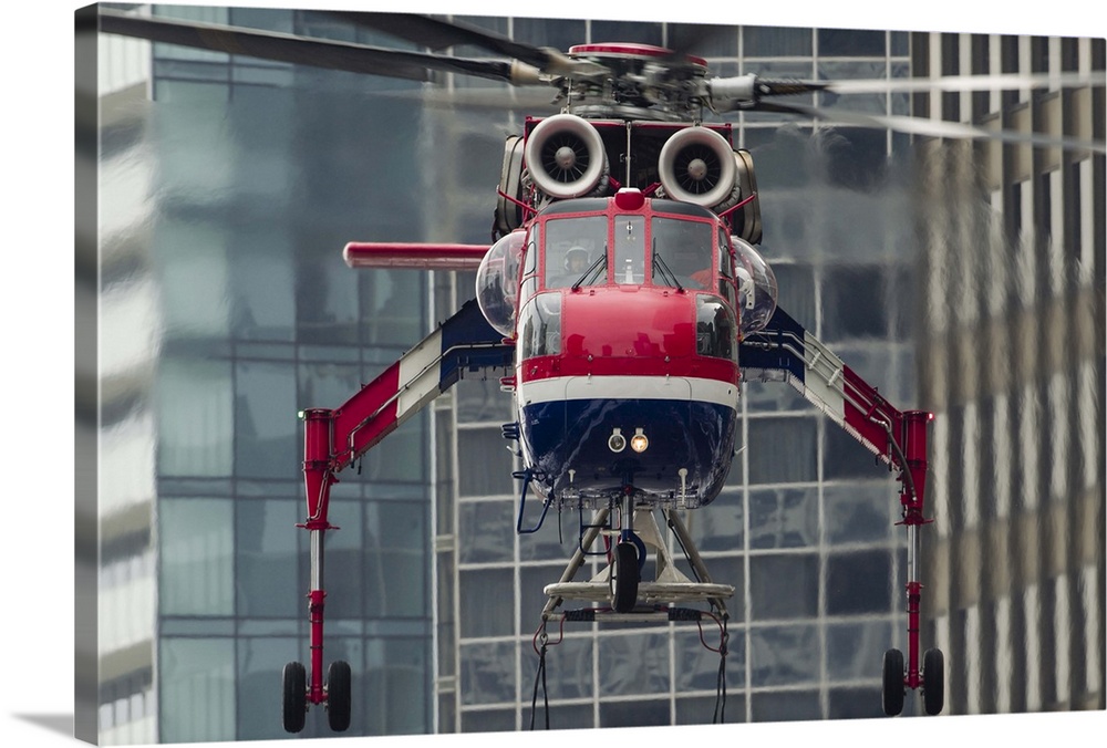 An Erickson Aircrane S-64 Aircrane hovers over a load, ready to lift it to the top of a building in Chicago, Illinois.